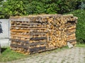 Stacked logs in front of a hedge