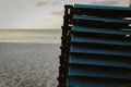 stacked lounge chairs against a beautiful beach backdrop and sunny sky with space for copy Royalty Free Stock Photo