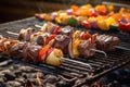 stacked meat skewers next to a classic stainless steel barbecue grill