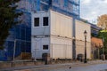 Stacked white modular container units, secured behind a fence at an urban construction site, provide temporary office space and Royalty Free Stock Photo