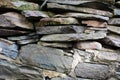 Stacked and mortared grey stone and flat rock wall