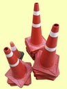 Stacked Orange White Striped Traffic Road Cones Isolated on Yellow Royalty Free Stock Photo