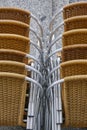 Stacked outdoor metallic and plastic chairs. City background