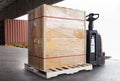 Stacked of package boxes on pallet rack and forklift pallet jack waiting to load into shipping container. Cargo shipment boxes. Royalty Free Stock Photo