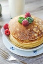 Stacked pancakes raspberries mint sugar milk