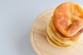 Stacked pancakes on a round wooden cutting board