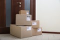 Stacked parcels near door on floor, space for text. Delivery service Royalty Free Stock Photo
