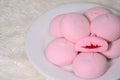 Stacked pink buns in a white porcelain plate on the table