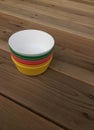 Colorful plastic bowls on wood background. Royalty Free Stock Photo