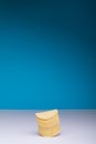 Stacked potato chips on table against blue background with copy space