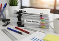 Stacked printed documents with paper clips labeled \'Team Review\' placed Royalty Free Stock Photo