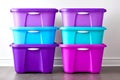 Stacked purple and turquoise storage bins sit against a plain wall, providing a stylish and functional solution for organizing Royalty Free Stock Photo