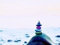 Stacked rounded stones at sea. Polished pebbles on dark wet rock, smooth water