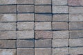 Stacked in several horizontal rows of gray decorative bricks for the pavement, top view. Stone background.