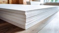 Stacked sheets of textured insulation foam on a wooden surface in a bright workspace Royalty Free Stock Photo