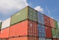 Stacked shipping containers against blue sky and clouds