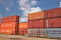 Stacked shipping containers against blue sky, some clouds