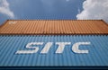 Stacked shipping containers soars into blue sky