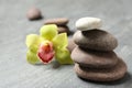 Stacked spa stones with flower on grey table Royalty Free Stock Photo