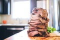 stacked spiced shawarma meat before grilling, close-up in kitchen