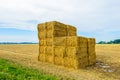 Stacked straw bales in front of a large stubble field Royalty Free Stock Photo