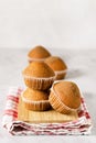 Stacked Tasty Vanilla Muffins on Wooden Tray Gray Red Linen Napkin Background Vertical