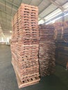 Stacked timber planks arranged vertically inside a spacious industrial warehouse Royalty Free Stock Photo