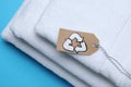 Stacked towels with recycling label on light blue background Royalty Free Stock Photo