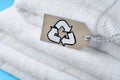 Stacked towels with recycling label on light blue background, closeup Royalty Free Stock Photo