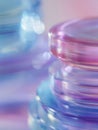 Stacked transparent circular containers reflecting soft purple and blue light with dreamy bokeh effect creating an abstract Royalty Free Stock Photo