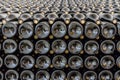 Stacked unlabelled wine bottles at winery