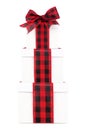 Stacked white Christmas gift boxes with red and black buffalo plaid bow and ribbon isolated on white Royalty Free Stock Photo