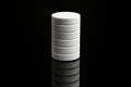 Stacked white circular objects against a dark surface showcasing minimalist design and texture Royalty Free Stock Photo