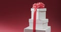 Stacked white gift boxes with a pink ribbon on a red background Royalty Free Stock Photo