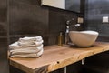 Stacked white spa towels on wooden table at modern bathroom