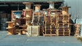 Stacked wooden pallets and wooden coil of electric cable on warehouse