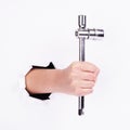 Stacked wrench in the hand of a girl. Symbol of hard work, feminism and labor day. Isolate on white background