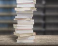 Stacking books on wood desk with blur bookshelfs background