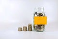 stacking coin and coin in the bottle with sticky note Royalty Free Stock Photo