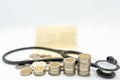 Stacking coins arranged as growth graph with soft focus of Stethoscope and bookbank Royalty Free Stock Photo