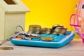 Stacking coins and bunch of key on calculator, piggy bank and house replica on wooden desk