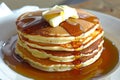 stacking pancakes, syrup and butter ready to serve