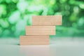 3 stacking rectangle empty wooden blocks on table with green natural blur background