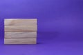 Stacking 3 rectangle empty wooden blocks on table with light purple background for own customer text or letters. Idea of