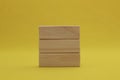 Stacking 3 rectangle empty wooden blocks on table with yellow background for own customer text or letters. Idea of environment,