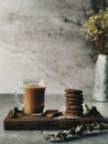 Stacks of biscuits and a cup of coffee milk on a wooden board Royalty Free Stock Photo