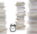 Stacks of books with alarm clock isolated on white background Royalty Free Stock Photo