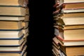 Stacks of books in red, blue, green covers on black isolated background. Rows of old books with paper pages. Literature Royalty Free Stock Photo