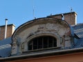 Stacks and brick chimneys and arched old dormer on sloped metal roof Royalty Free Stock Photo