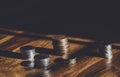 Stacks  British money pound coins on wooden table, Selective focus GBP coins on the floor with shadow and light in dark room, Royalty Free Stock Photo